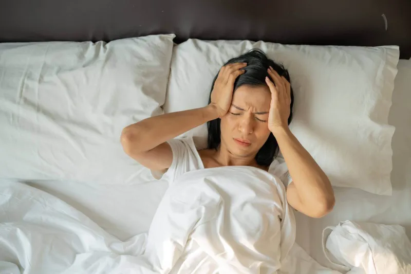 woman lying in bed migraine treatments in miami 1